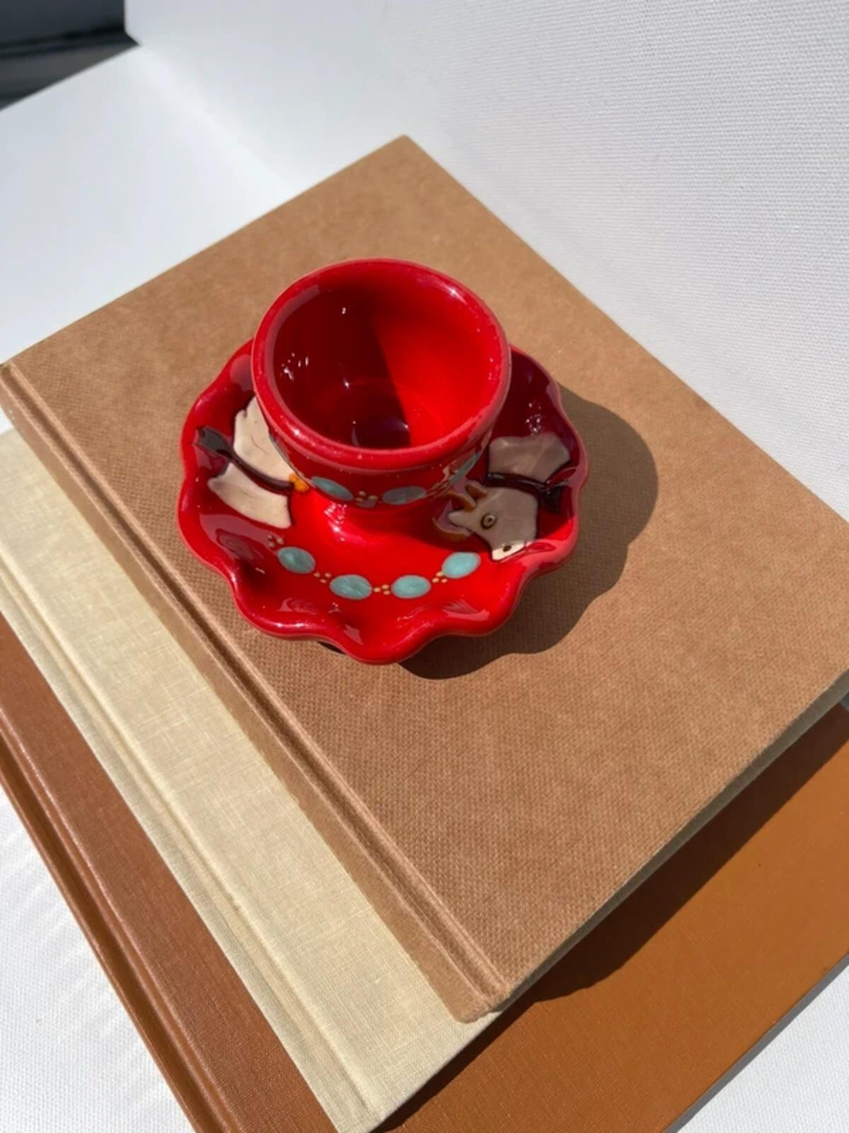 Handpainted studio pottery red waved egg cup with cow motif