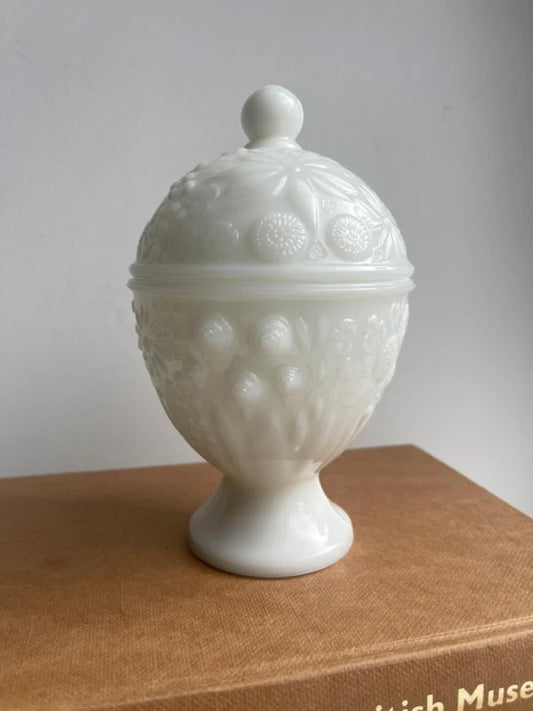 Vintage Avon white milk glass lidded trinket holder with embossed floral design, collectible vanity jar, decorative candy dish, classic cottagecore home decor, jewellery storage and farmhouse display.